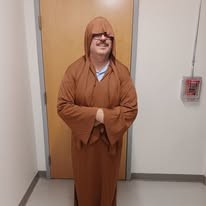 Ted in a brown hooded medieval monk's robe
