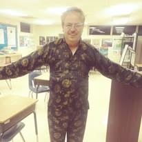 Ted in an ornate black and gold patterned robe in a classroom