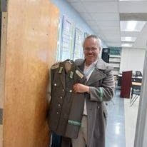 Ted smiling while displaying a decorated military dress uniform